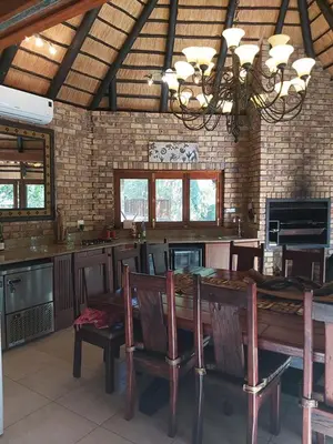 a dining room with a table and some chairs at Dreamy 3 bedroom villa on the edge of the Sabie River in Kruger Park Lodge in Hazyview