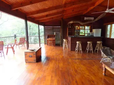 a large living room with wooden floors and tables and chairs at Zazu Private Bush Lodge, Formerly Masodini in Hoedspruit
