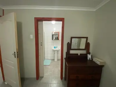a bathroom with a sink and a vanity and a mirror at Man and Dog Log Cabin in Midrand