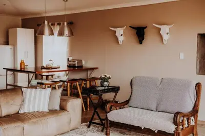 a living room with a couch and antlers on the wall at Sorgenfri in Hendrina