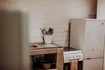 a kitchen with a sink and a counter with a refrigerator at Sorgenfri in Hendrina