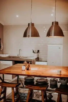 a kitchen with a wooden table and some pots and pans at Sorgenfri in Hendrina