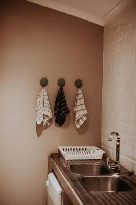 a kitchen with a sink and towels on the wall at Sorgenfri in Hendrina