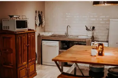 a kitchen with a sink and a microwave and a table at Sorgenfri in Hendrina