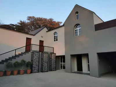 a house with a staircase and potted plants at The Lion Mansion - on Solar live and work anywhere in Pretoria