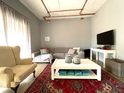 a living room with a couch and a table at The Lion Mansion - on Solar live and work anywhere in Pretoria