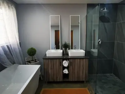 a bathroom with two sinks and a shower at The Lion Mansion - on Solar live and work anywhere in Pretoria