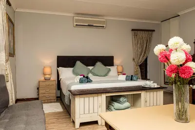 a bedroom with a bed with a vase of flowers at Mereke Manor in Centurion