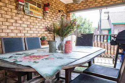 a wooden table with a table cloth on a patio at Mereke Manor in Centurion