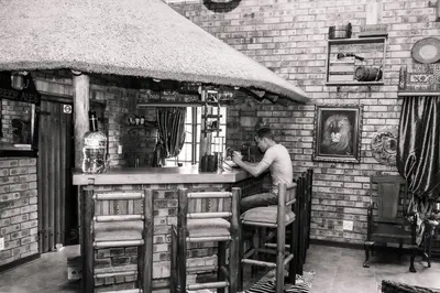 a man sitting at a bar in a pub at Mereke Manor in Centurion