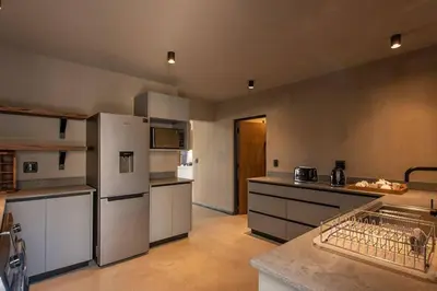 a large kitchen with a refrigerator and a counter at Luxury Villa looking onto Kruger National Park in Belfast