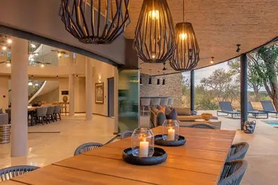 a dining room with two candles on a wooden table at Luxury Villa looking onto Kruger National Park in Belfast
