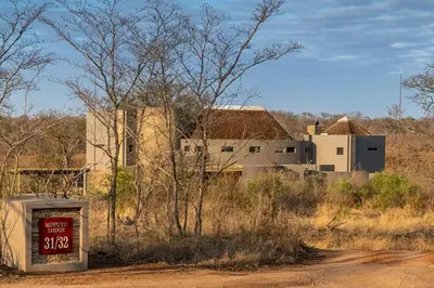 a building in the middle of a field with a gas pump at Luxury Villa looking onto Kruger National Park in Belfast
