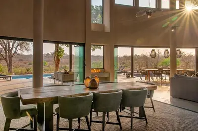 a large dining room with a table and chairs at Luxury Villa looking onto Kruger National Park in Belfast