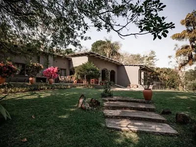 a house with a yard with some stairs in front of it at Linvale Country Lodge in Hazyview