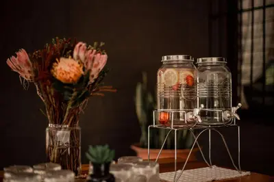 a table with a vase of flowers and two glass jars at Linvale Country Lodge in Hazyview