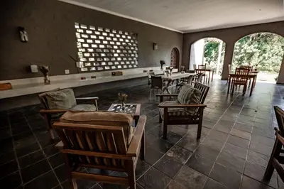 a dining room with chairs and tables and a large window at Linvale Country Lodge in Hazyview