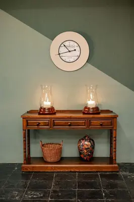 a table with two vases and a clock on the wall at Linvale Country Lodge in Hazyview