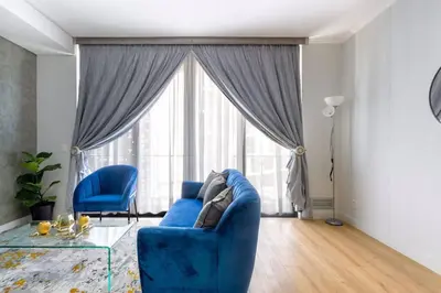 a living room with a blue couch and a large window at Alimama Spaces: The Manson Newton Villa Ellipse in Midrand