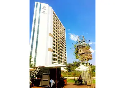 a tall building with a tree on the side of it at Menlyn Apartment - Trilogy in Pretoria