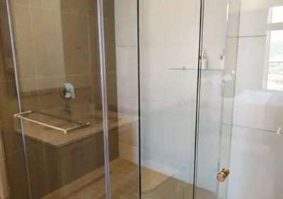 a shower with a glass door in a bathroom at Menlyn Apartment - Trilogy in Pretoria