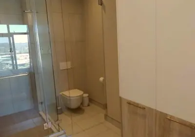 a bathroom with a toilet and a glass shower at Menlyn Apartment - Trilogy in Pretoria