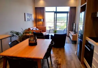 a living room with a wooden table and a living room at Menlyn Apartment - Trilogy in Pretoria