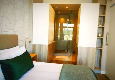 a bedroom with a bed and a walk in shower at Menlyn Apartment - Trilogy in Pretoria
