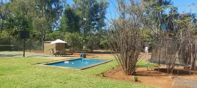 a small swimming pool in a yard with a tree at Vulture's View 3 in Hartbeespoort