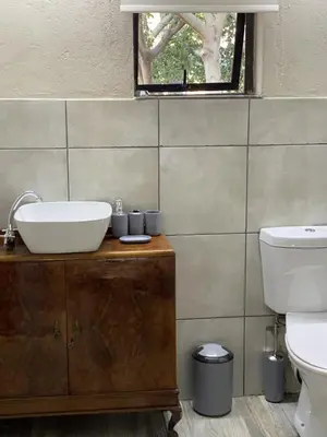 a bathroom with a sink and a toilet at Sunset Guesthouse and Venue Cullinan in Meule