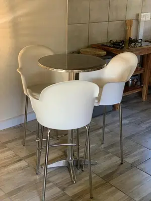 a table with four white chairs and a table at Sunset Guesthouse and Venue Cullinan in Meule