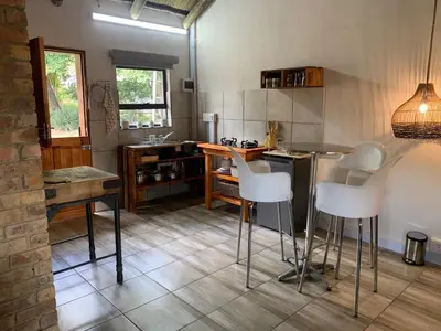 a kitchen with a table and chairs in a room at Sunset Guesthouse and Venue Cullinan in Meule
