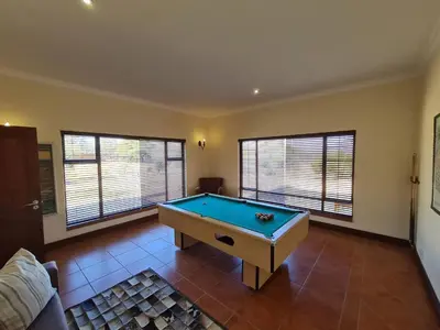 a living room with a pool table in it at Zebula No 2 Waterbergs Over the Savannah 4 Bedroom in Mabula
