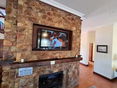 a stone fireplace with a television on top of it at Zebula No 2 Waterbergs Over the Savannah 4 Bedroom in Mabula