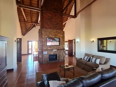 a living room with a couch and a fireplace at Zebula No 2 Waterbergs Over the Savannah 4 Bedroom in Mabula