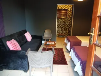 a living room with a couch and a bed at Aloha Menlyn Lodge Ensuite Rooms with shower all with own entrance and unlimited free WiFi in Pretoria