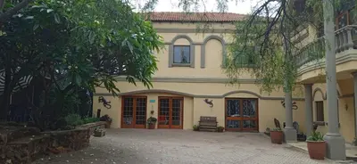 a large house with two doors and a courtyard at Aloha Menlyn Lodge Ensuite Rooms with shower all with own entrance and unlimited free WiFi in Pretoria