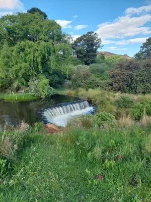 a waterfall in the middle of a river at Watersmeet cottages in Dullstroom