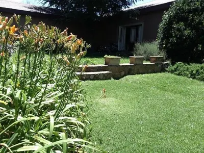 a yard with a garden with some plants and flowers at Watersmeet cottages in Dullstroom
