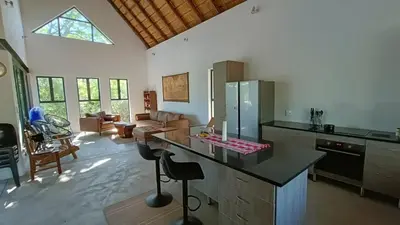 a kitchen with a counter top and a living room at Marloth Park, Kruger safari house - solar in Marloth Park