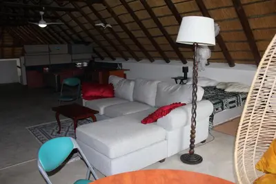 a living room with a white couch and a lamp at Marloth Park, Kruger safari house - solar in Marloth Park