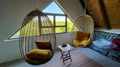 three hanging chairs in a room with a window at Marloth Park, Kruger safari house - solar in Marloth Park