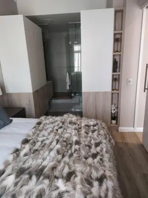 a bedroom with a faux fur blanket on the floor at 317 Menlyn Maine Trilogy in Pretoria