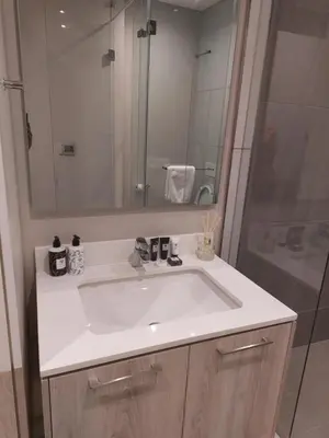 a bathroom with a white sink and a shower at 317 Menlyn Maine Trilogy in Pretoria