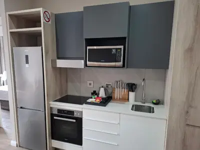 a small kitchen with a refrigerator and a microwave at 317 Menlyn Maine Trilogy in Pretoria