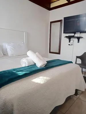 a bedroom with a bed with two towels on it at PARK FRONT LODGE in Polokwane