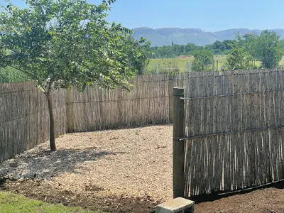 a wooden fence with a tree in front of it at Bossi Lodge in Hartbeespoort
