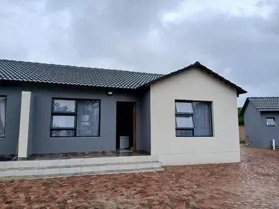 a white home with a black roof at Bossi Lodge in Hartbeespoort