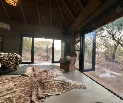 a bedroom with a giraffe rug on the floor at Simba Safaris African Pride Exotic Lodge in Lephalale