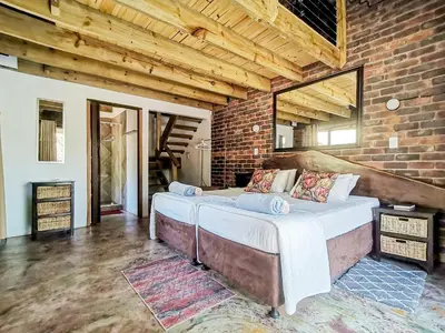 a bedroom with two beds in a brick wall at Athule Inn Marloth - Units in Marloth Park
